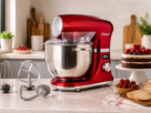Visão detalhada da Oster Batedeira Planetária Digital vermelha com bowl de inox de 5 litros, destacando o display eletrônico e painel de controle lateral.